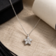 Colgante de estrella luminosa. Las piedras incoloras recorren las puntas del motivo.