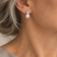 Pendientes de perla y frente luminoso. La montura superior presenta pequeñas garras visibles.