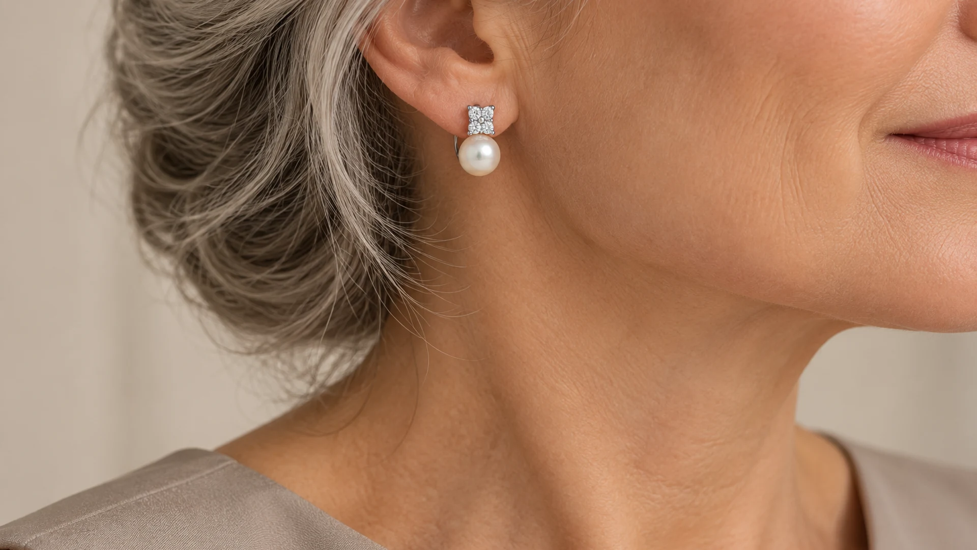 Pendientes de perla y frente luminoso. La montura superior presenta pequeñas garras visibles.