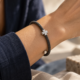 Pulsera de acero con motivo de cruz. Las pequeñas piedras incoloras recorren los brazos del centro.