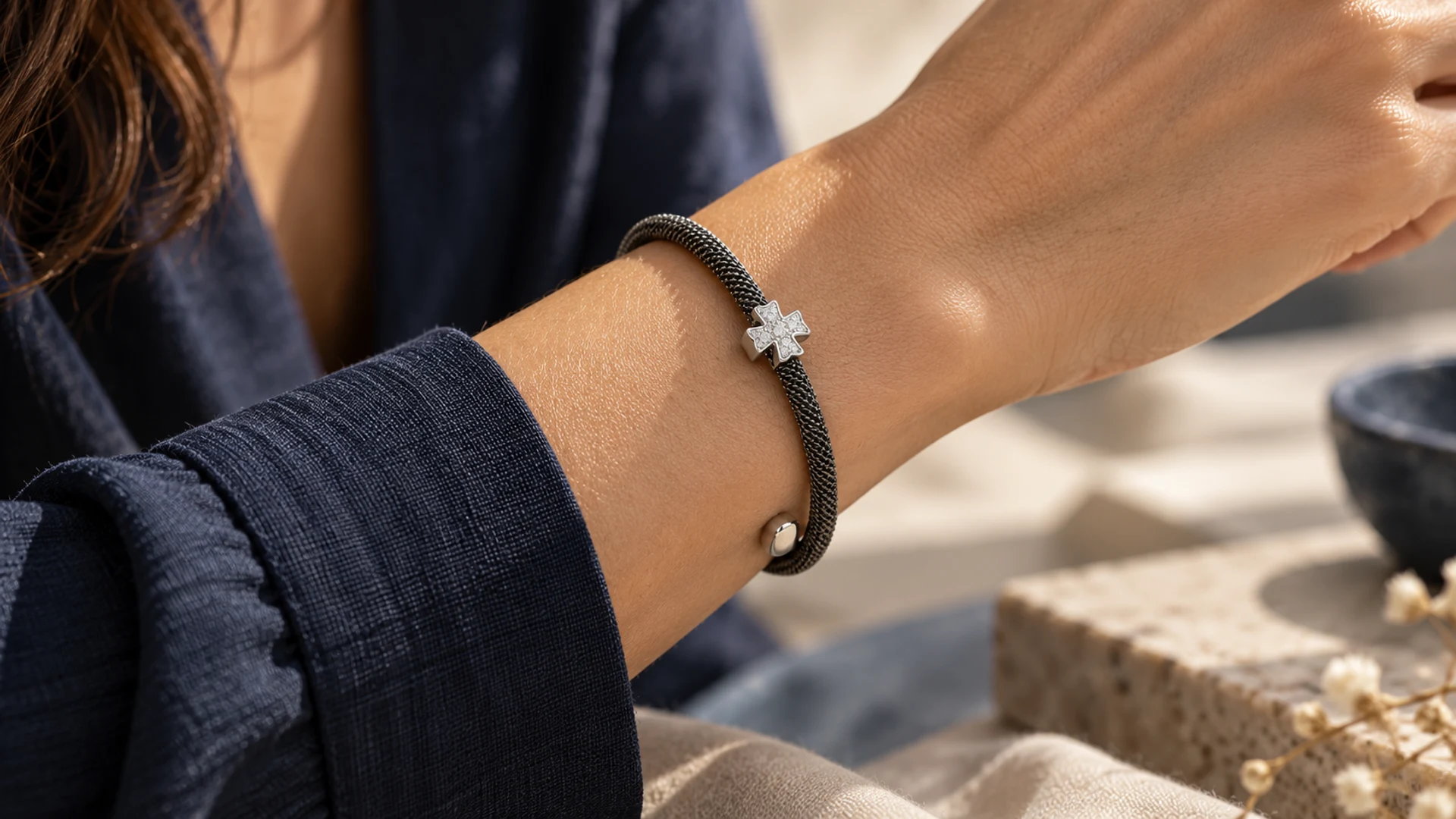 Pulsera de acero con motivo de cruz. Las pequeñas piedras incoloras recorren los brazos del centro.